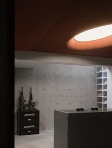 An industrial-style office with concrete walls, a reception desk, and organized shelves.