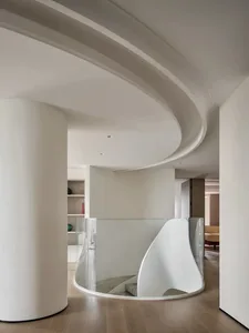 Modern living room interior featuring a sleek, glass-enclosed staircase