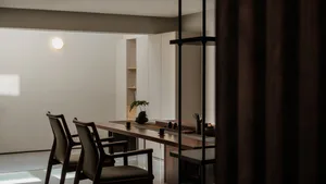 A modern minimalist living room featuring wood furniture and a clean, open floor plan.