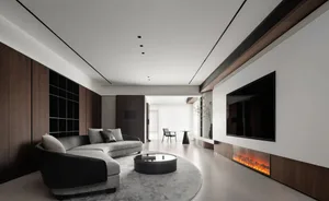 A modern minimalist living room with a large black and white sofa, a black and white circular coffee table, and a large telev