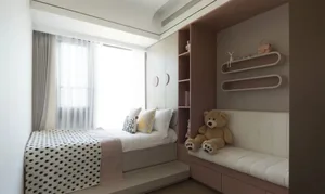 A modern neutral-toned bedroom featuring a bed with a polka-dotted blanket, a teddy bear, and a shelf with decorative items.
