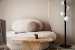 A modern living room with a marble table and a textured sofa.