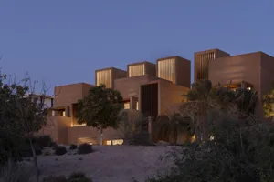 Modern building featuring concrete and glass materials under twilight sky.