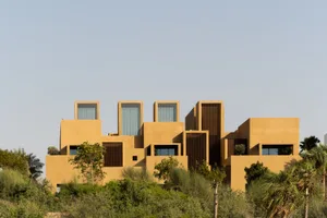 Modern architecture building with sand-colored concrete exteriors and large glass windows.