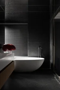 A modern bathroom with a marble bathtub and grey tiles.