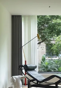 Modern living room featuring glass window with wooden floor and metal furniture.
