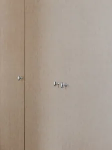 A minimalist wardrobe made of wood with metallic knobs.