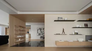 A modern living room featuring wooden shelves, a marble floor, and contemporary decor.