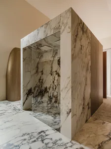 A modern, minimalist bathroom with marble walls and floor.