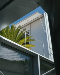 Modern residential exterior featuring concrete walls and greenery.