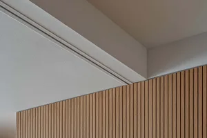 A modern interior design featuring a wall covered in wooden slats.
