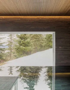 A modern interior with a large glass window providing a view of the natural surroundings