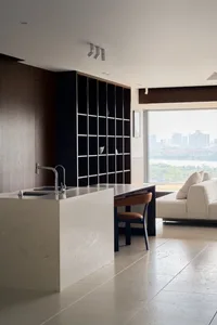 A modern apartment interior featuring a marble countertop and a gray palette.