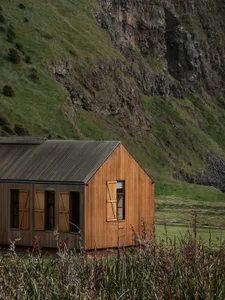 A modern house with wooden siding and a steep roof.