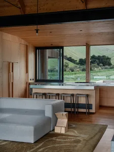 A modern interior design with wooden elements and a view of greenery outside.