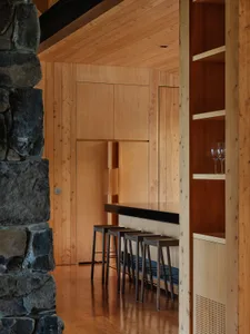 A modern kitchen with wooden walls and a black countertop.