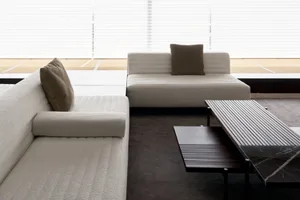 Modern living room featuring white couches and a coffee table.