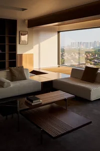 A contemporary living room with modern furniture, a large window, and a view of a cityscape.