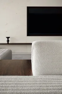 A modern living room with a cozy sofa upholstered in fabric.