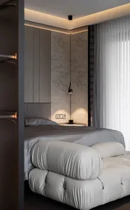 A minimalist bedroom with a white bed frame and light grey bedding, featuring a modern light fixture and a sleek, grey wardro
