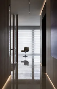 A minimalist office with a glass window and a single chair reflected in the glossy floor.