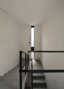 Modern staircase with black metal railings and concrete steps
