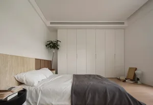 簡約臥室採用中性材質，並配有大型衣櫃。