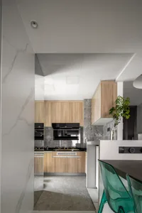 Modern kitchen interior with wooden cabinets and marble countertops.