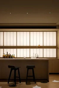 A modern interior bar featuring wooden surfaces and stools.