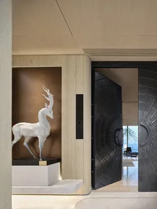 Modern lobby interior featuring a metal and wood design with a white deer statue and black door