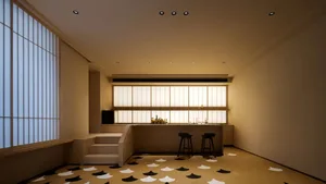 A minimalist bar space with a wooden counter, black stools, and wooden floors with a pattern of black and white geometric sha
