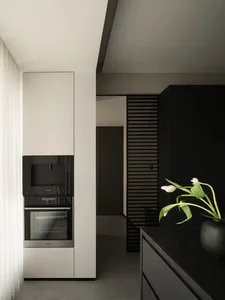 Modern minimalist kitchen featuring dark grey and black materials, concrete countertops, and sleek black appliances.