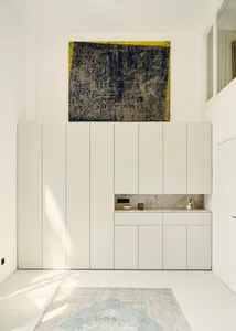 Modern minimalist interior with white cabinets and marble accents.