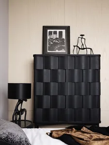 A modern black wood bedroom with furniture, a lamp, and decorative elements.