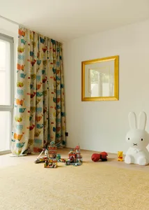 A children's room with playful decor, including colorful curtains, toys, and a large rabbit sculpture.