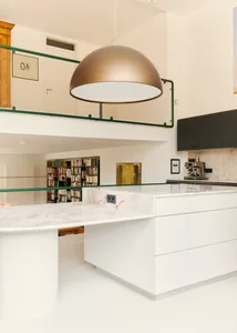A modern interior design featuring white cabinets and marble countertops in a kitchen setting.