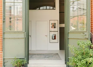 Modern minimalist entrance with concrete floor and framed artwork.