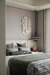 Modern bedroom featuring a bed with textured cushions and a textured wall panel.