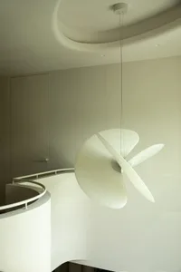 A modern hanging light fixture with a metallic and glass design