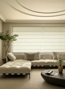 A modern minimalist living room featuring a white sectional sofa adorned with cushions in shades of beige, a round black coff