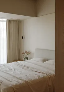 Modern bedroom with neutral colors, minimalist design, and a queen-sized bed.