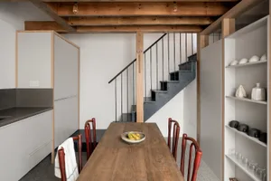 A modern kitchen with wooden elements and white cabinets.