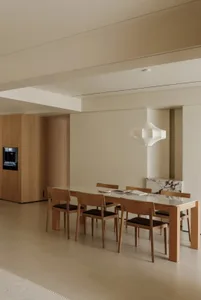 A modern residential dining room with a wooden floor, table, and chairs.