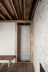 A modern industrial apartment with white walls and a wooden floor, featuring a minimalist design.
