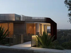 Contemporary residential exterior featuring modern architectural design with concrete, glass, and metal elements.