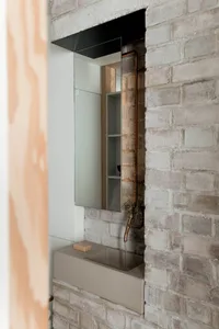 Concrete minimalist bathroom sink with exposed brick wall and copper pipes