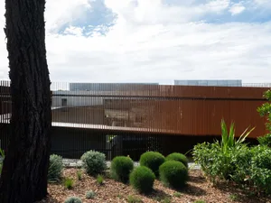 Modern exterior architecture featuring a metal-cladding wall and greenery.