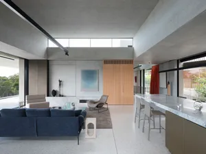 Modern living room featuring contemporary furniture, concrete floor, and large windows.