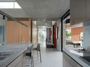Modern kitchen with concrete surfaces and minimalist design, featuring sleek countertops and industrial-style fixtures.