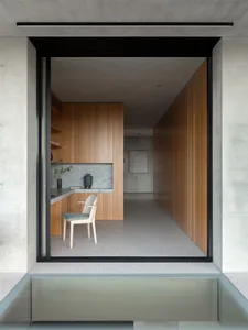 A minimalist kitchen featuring wooden cabinets and marble countertops.